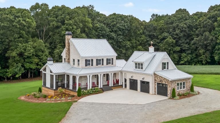 Elegant modern farmhouse with metal roof and stone accents by Jasper Builders.